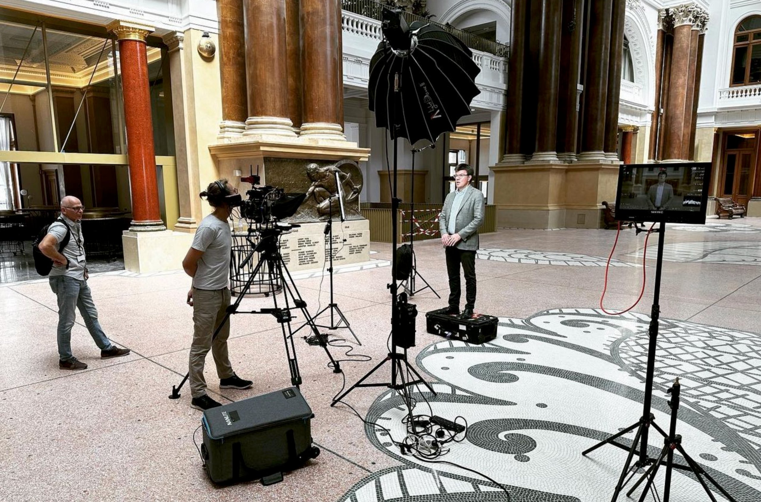 Fullscreen Productions video crew filming an institutional interview in a grand European hall